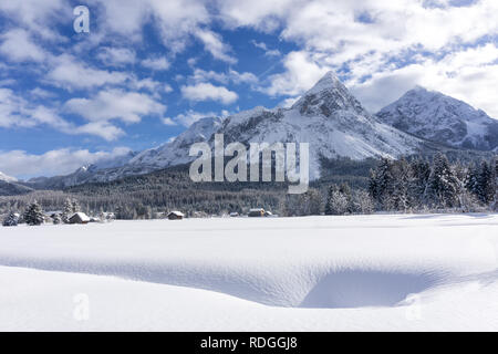 In inverno il paesaggio di montagna con valle coperta di neve fresca e cielo blu con nuvole bianche nella giornata di sole. Ehrwald valley, Tirol, Alpi, Austria. Foto Stock