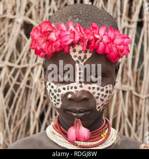 Karo ragazza con un archetto floreali, pitture facciali e colorati di collane e labbro piercing, ritratto, Omo river valley Foto Stock