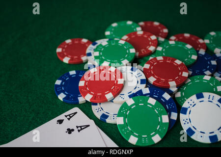 Pila di chips poker e due assi sul tavolo sul green baize. Vista prospettica. Foto Stock