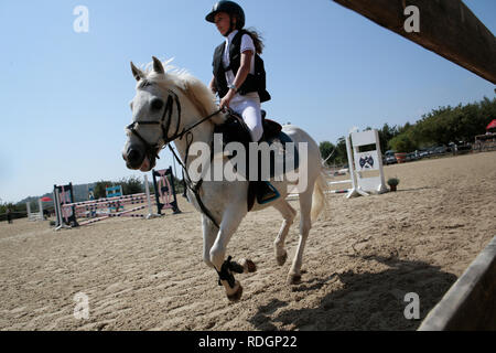 Giovani piloti competere sui loro cavalli e poney su un locale competizione equestre nell'isola spagnola di Ma Foto Stock