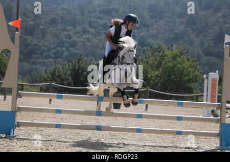 Giovani piloti competere sui loro cavalli e poney su un locale competizione equestre nell'isola spagnola di Ma Foto Stock