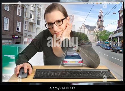 Giovane donna seduta a un computer utilizzando Google Street View, dettaglio di immagine con una sezione della città di Amsterdam, persone e Foto Stock