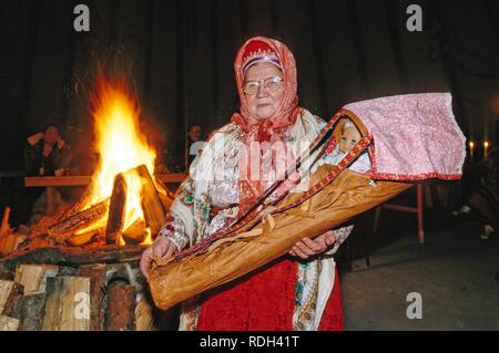 Donna del Samit oder Samek gruppo etnico che indossano il costume tradizionale portando un baby basket, Norvegia, Europa Foto Stock