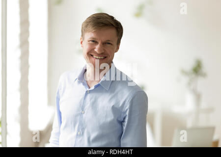 Colpo alla testa ritratto di successo imprenditore sorridente guardando Foto Stock