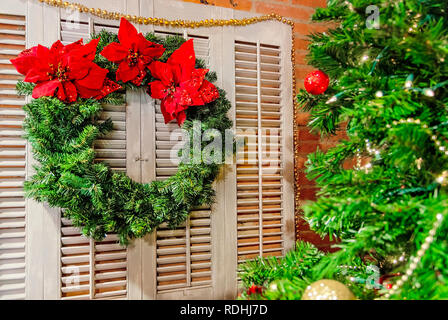 Una corona è visualizzata accanto a un albero di Natale presso il Forte di mobili coloniali, Dic 23, 2018 in Mobile, Alabama. Foto Stock