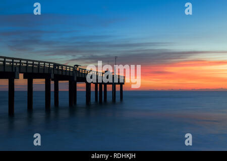 Una lunga esposizione al sunrise presso la storica St Augustine Beach Pier, o St. Johns County Ocean Pier, in Sant'Agostino, Florida Foto Stock