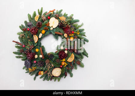 Bellissima fatta a mano ghirlanda di Natale isolato su sfondo bianco, verde abete rami decorato con pigne e altre decorazioni Foto Stock