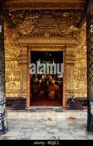 Luang Prabang / Laos - Lug 06 2011: i monaci buddisti pregano durante un pomeriggio cerimonia al loro wat Foto Stock