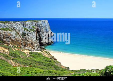 In un momento di relax a una bella spiaggia bianca a Algarve Portogallo vicino a Sagres con grandi rocce in background Foto Stock