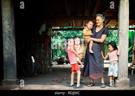 Luang Namta / Laos - Lug 06 2011: lao famiglia con madre e simpatici ragazzi in attesa sotto la loro casa stilt Foto Stock