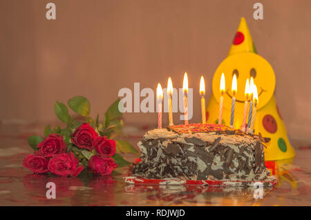 Torta al cioccolato con candele e rose rosse per il giorno di san valentino, madri di giorno o di compleanno Foto Stock