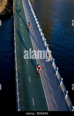 Un runner e ciclisti sul lungofiume cycleway/passerella, Brisbane city centre, Queensland, Australia Foto Stock