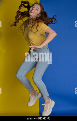 La modellazione femmina in giallo e blu abbigliamento per abbinare il suo background Foto Stock