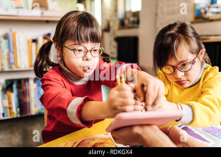 Carino incantevole sorelle con anormalità cromosomiche Disegno con matite colorate Foto Stock