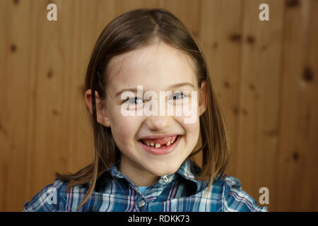 Piccola ragazza sorridente, mostrando il suo allentato e mancano i denti di latte. Giocoso e allegro infanzia, dente fata, la crescita e la pietra miliare del concetto. Foto Stock