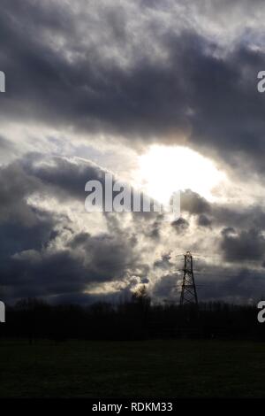 Stagliano National Grid pilone dell contro una drammatica Wintery cielo nuvoloso. Exeter Devon, Regno Unito. Foto Stock