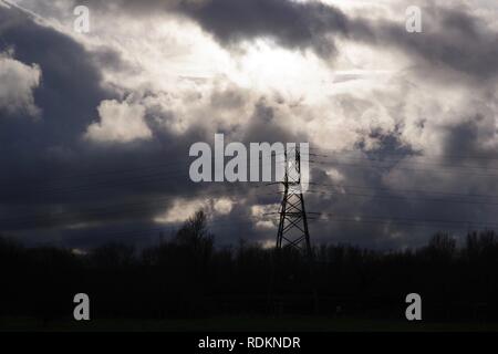 Stagliano National Grid pilone dell contro una drammatica Wintery cielo nuvoloso. Exeter Devon, Regno Unito. Foto Stock