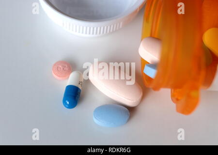 Pillole medicinali spill bottiglia sfondo bianco Foto Stock