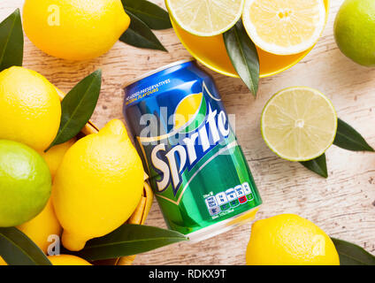 LONDON, Regno Unito - 15 gennaio 2019: Alluminio può di Sprite bere su sfondo di legno con limoni e limette. Sprite è limone-come aromatizzati soft drink prod Foto Stock