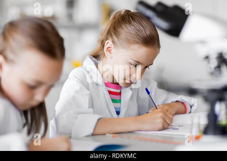 I ragazzi che studiano la chimica in laboratorio scolastico Foto Stock