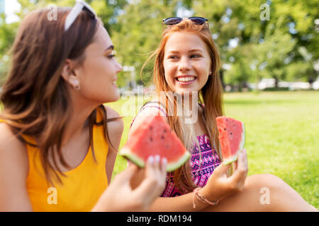 Le ragazze adolescenti mangiando anguria a picnic nel parco Foto Stock