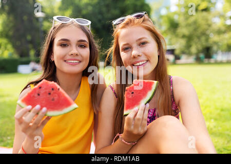 Le ragazze adolescenti mangiando anguria a picnic nel parco Foto Stock