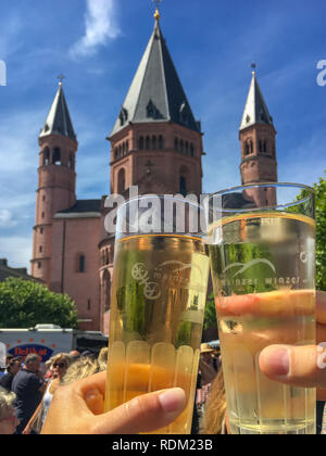 Mainz, Germania - 29 Luglio 2017: due bicchieri tintinnanti con spritzer (Weinschorle) in Mainzer Marktfruehstueck nella parte anteriore della Cattedrale di Magonza in estate Foto Stock