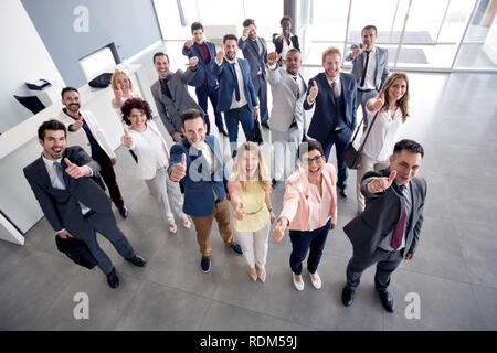 Sorridendo allegro gruppo aziendale dando pollice in alto Foto Stock