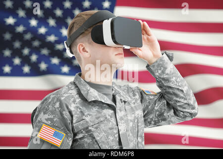 In ambienti chiusi shot del soldato USA indossare occhiali per realtà virtuale con bandiera americana sullo sfondo Foto Stock