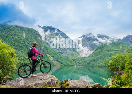 Percorsi in bicicletta donna in Norvegia contro il pittoresco paesaggio Foto Stock