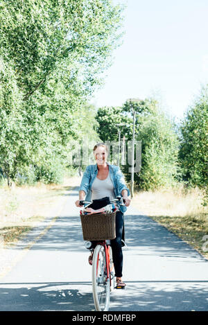 Donna incinta escursioni in bicicletta Foto Stock