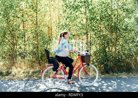 Donna incinta escursioni in bicicletta Foto Stock