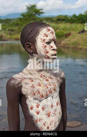 Surma ragazzo con trattamenti per il viso e per il corpo della pittura, Kibish, Omo River Valley, Etiopia, Africa Foto Stock