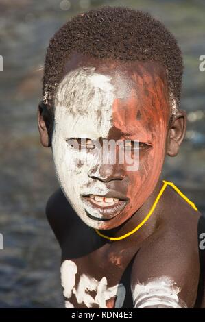 Surma ragazzo con trattamenti per il viso e per il corpo della pittura, Kibish, Omo River Valley, Etiopia, Africa Foto Stock