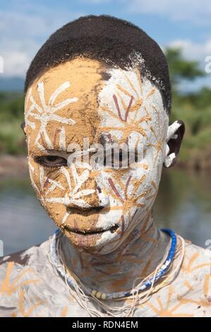 Surma ragazzo con trattamenti per il viso e per il corpo della pittura, Kibish, Omo River Valley, Etiopia, Africa Foto Stock