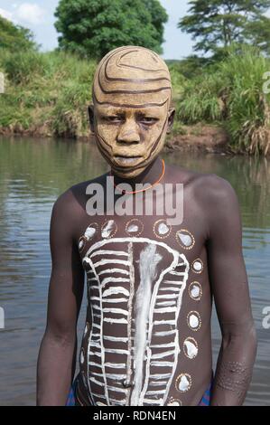 Surma ragazzo con trattamenti per il viso e per il corpo della pittura, Kibish, Omo River Valley, Etiopia, Africa Foto Stock