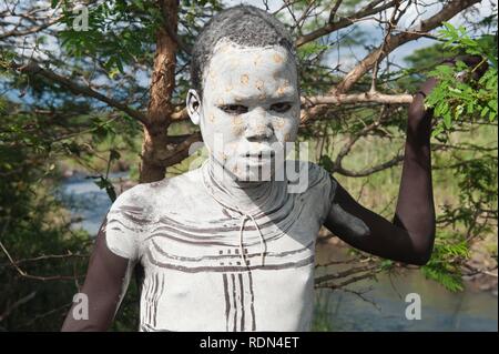 Surma ragazzo con trattamenti per il viso e per il corpo della pittura, Kibish, Omo River Valley, Etiopia, Africa Foto Stock