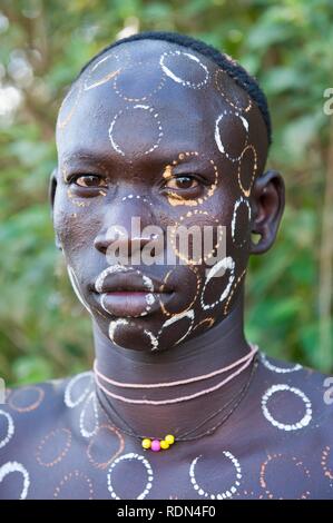 Surma uomo con trattamenti per il viso e per il corpo della pittura, Kibish, Omo River Valley, Etiopia, Africa Foto Stock