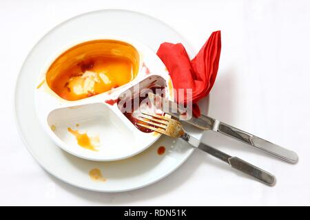 Resti di un pre-preparato pasto dopo essere mangiato, servita su un piatto e nella confezione originale Foto Stock