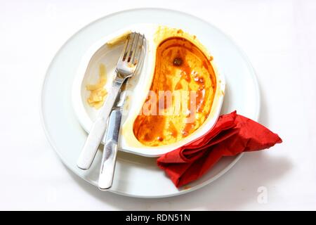 Resti di un pre-preparato pasto dopo essere mangiato, servita su un piatto e nella confezione originale Foto Stock