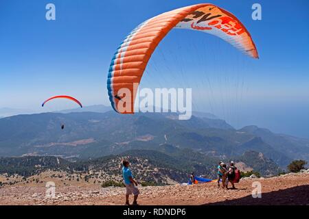 Il parapendio dal monte Baba Dagi a Oludeniz o Olu Deniz Bay nei pressi di Fethiye, nella costa occidentale della Turchia, Asia Foto Stock