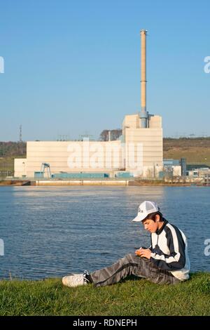 Ragazzo giocando nella parte anteriore del Kruemmel Centrale Nucleare, sull'Elba in Geesthacht, Schleswig-Holstein Foto Stock