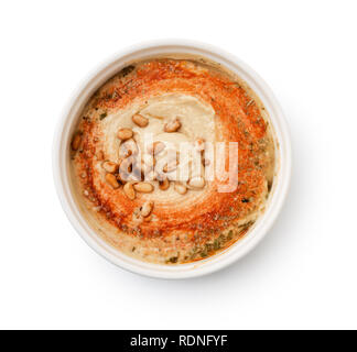 Vista dall'alto di hummus con pinoli nel recipiente isolato su bianco Foto Stock