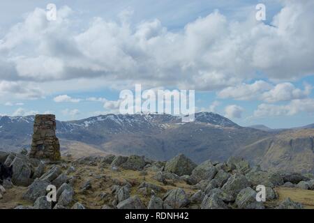 Cairn e formazione di roccia al vertice di alto sollevamento: una montagna nel Lake District inglese (Cumbria, Regno Unito). Lichene grigio coperto di massi, inesplosi su Foto Stock