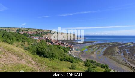 Vista sul villaggio e sulla baia con la bassa marea, Robin Hood's Bay, England, Regno Unito Foto Stock