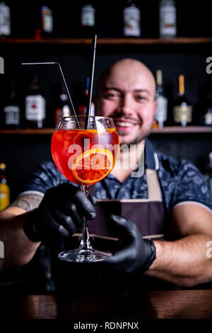Barman messa a bicchiere di fresco e gustoso Aperol siringa pace cocktail di ghiaccio Foto Stock