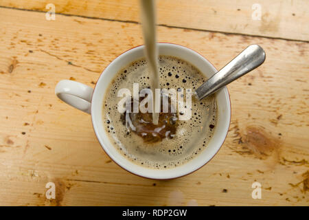 Vista aerea del latte essendo versata nella tazza da caffè Foto Stock