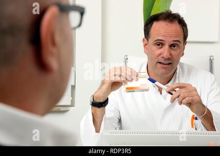 Ambulatorio medico, parlando a un paziente, discutendo il trattamento con un farmaco Foto Stock