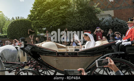 WINDSOR, Inghilterra - 19 Maggio 2018: la luce solare flare oltre il principe Harry, duca di Sussex e Meghan, duchessa di Sussex Windsor Castle icarriage durante una processione dopo esserci sposati presso la Cappella di St Georges Foto Stock