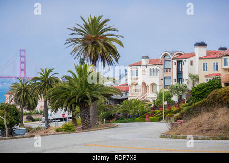 Strada residenziale nella scogliera sul mare quartiere, Golden Gate bridge in background, San Francisco, California Foto Stock